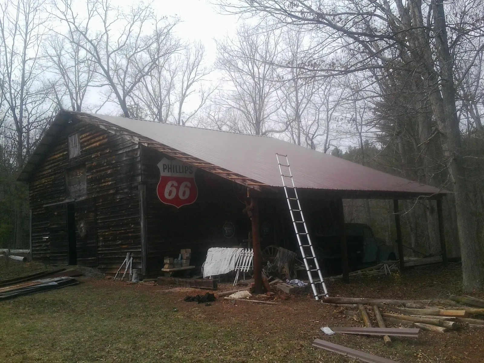 New metal roof on an open sided timber barn with a vintage sign in Seekonk