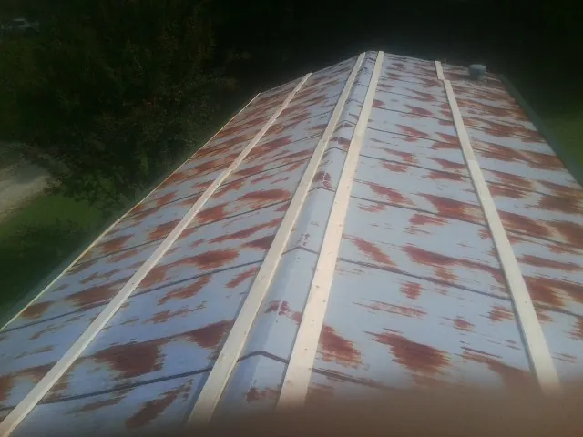 Rusted metal roof panels with new wood purlins before replacement — Storm Damage Roof Repair in Seekonk by Roofing Brothers