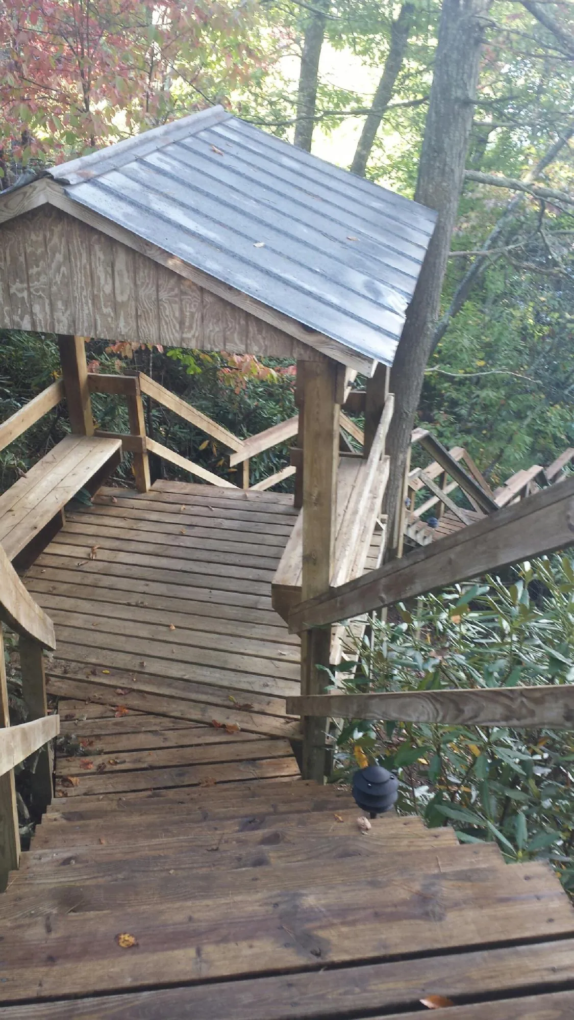 Metal roofed shelter over wooden steps on a wooded walkway — Skylight Repair & Installation work by our crew in Seekonk